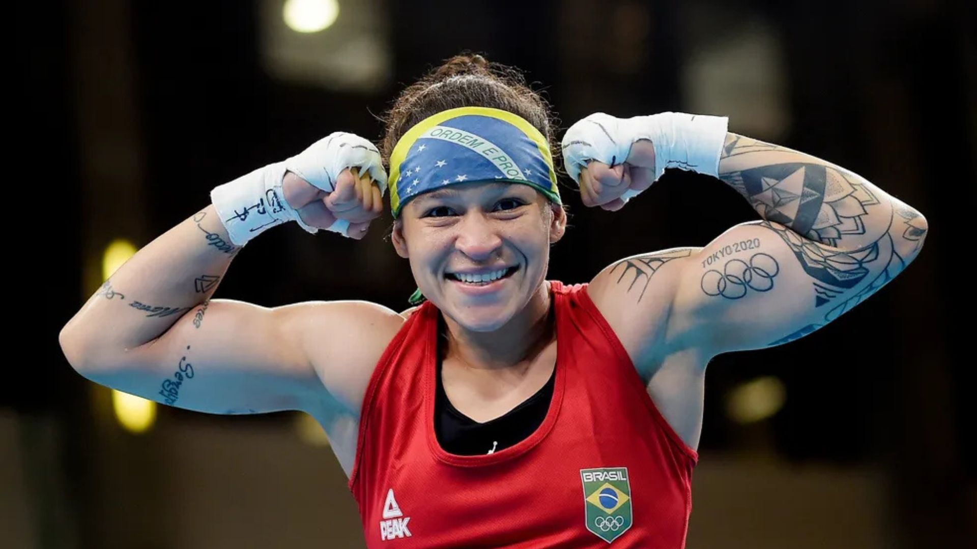 Bia Ferreira levanta os braços em comemoração após a vitória no ringue