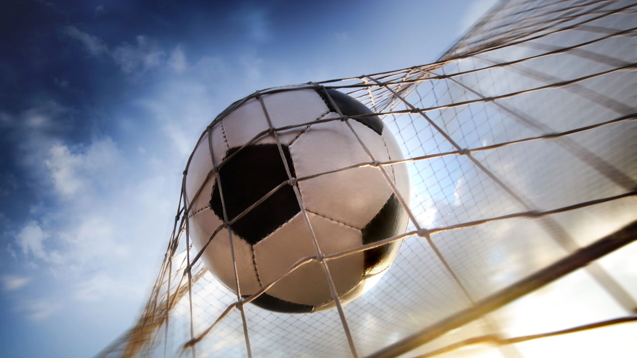 news.img_alt Jogador de futebol chutando a bola em um gol espetacular